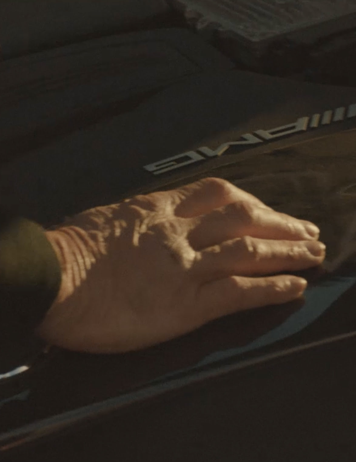 Hand of Bart Hickey, a blind mechanic, touching a Mercedes-AMG car.