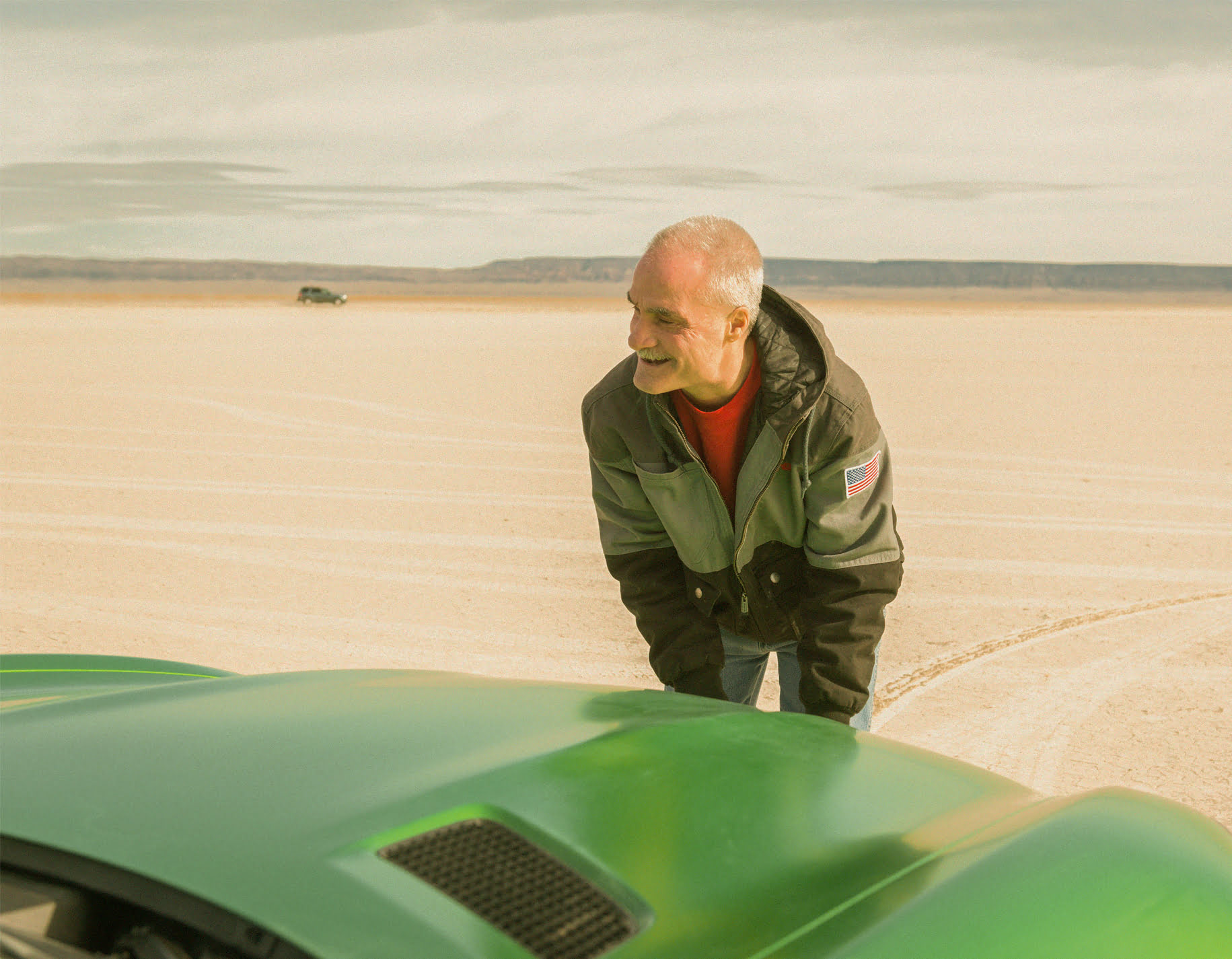 Picture of Bart Hickey, a blind mechanic, next to a Mercedes-AMG car in the desert