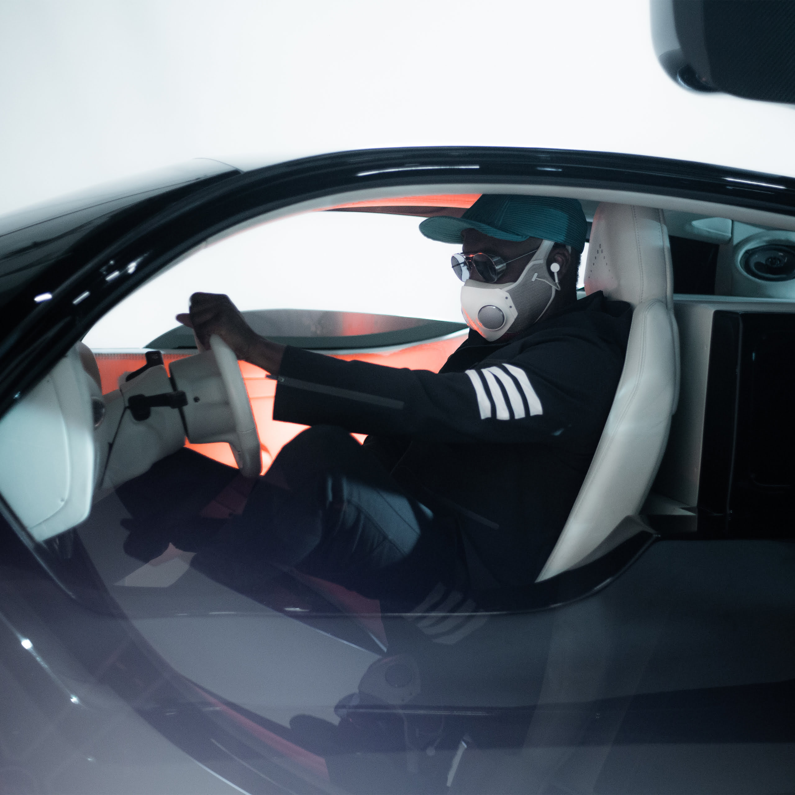 A photo of Will.I.Am sitting in his Mercedes-AMG car.